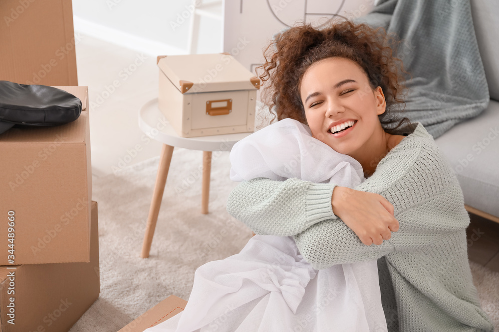 Young woman unpacking moving boxes in her new home