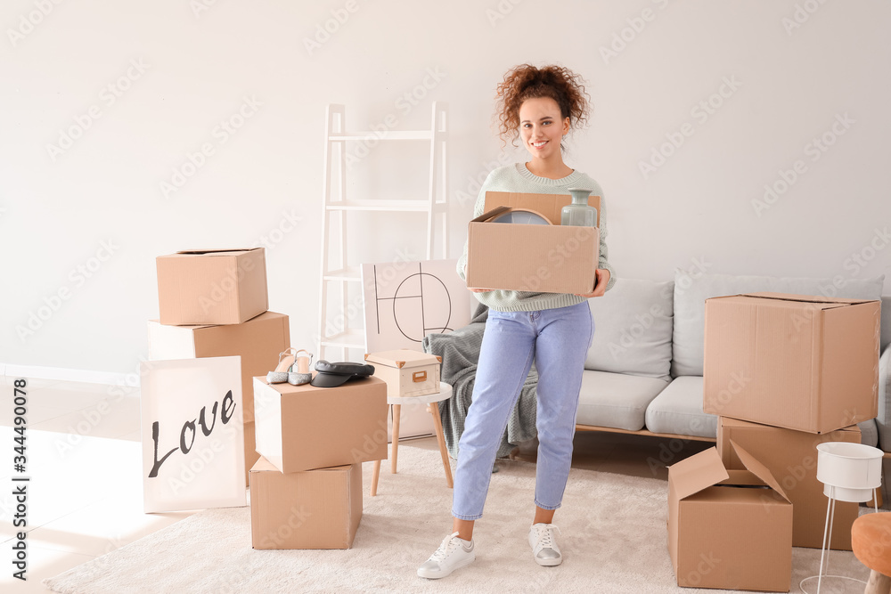 Young woman with moving boxes in her new home