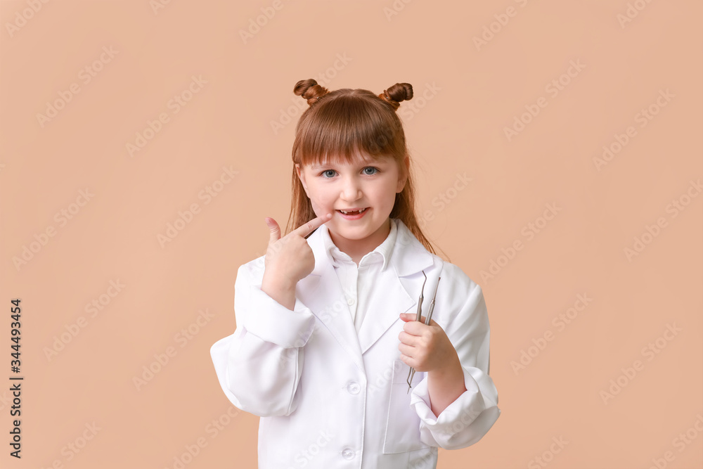 Little dentist with tools on color background