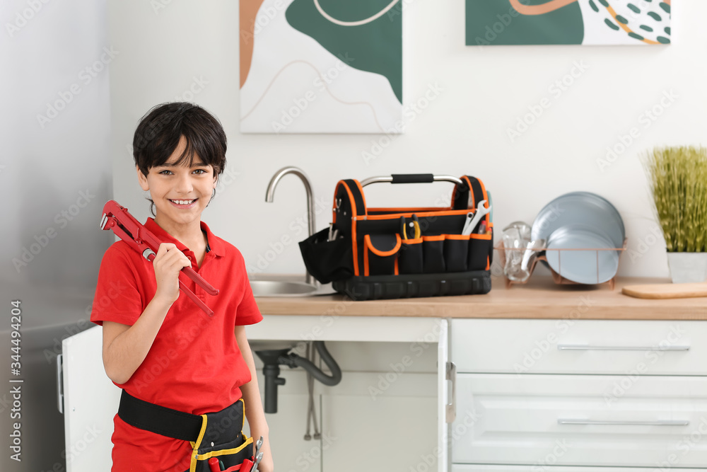 Portrait of little plumber in kitchen