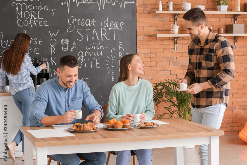 Colleagues drinking coffee in kitchen of office