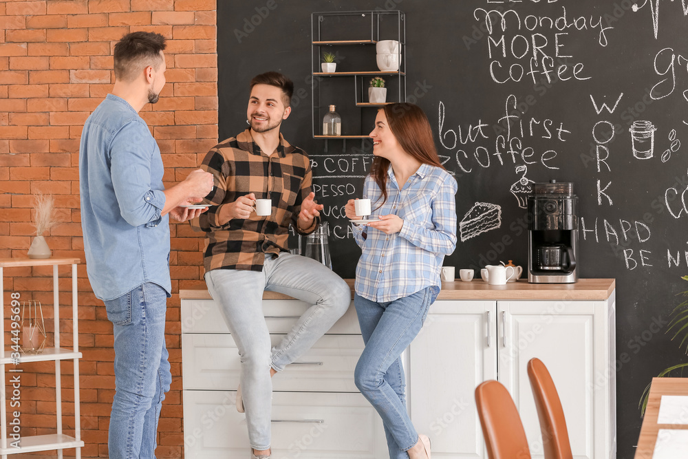 Colleagues drinking coffee in kitchen of office