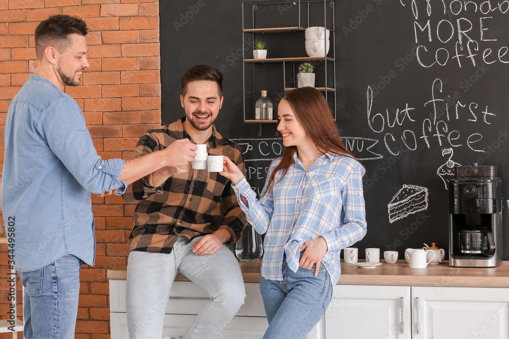 Colleagues drinking coffee in kitchen of office