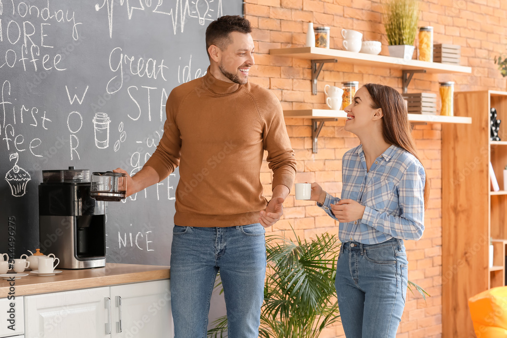 Colleagues drinking coffee in kitchen of office