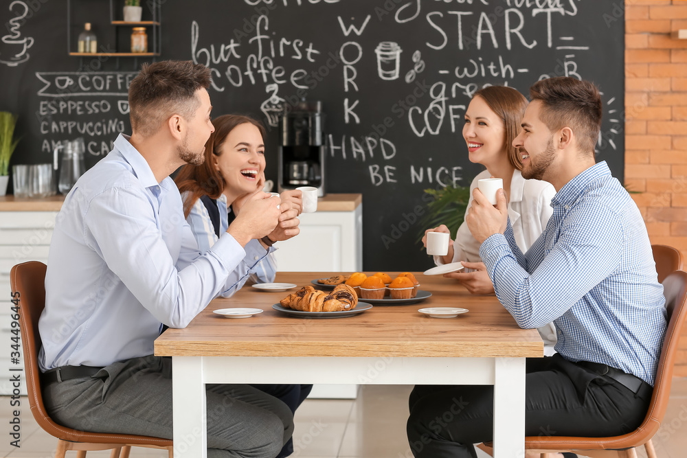 Colleagues drinking coffee in kitchen of office