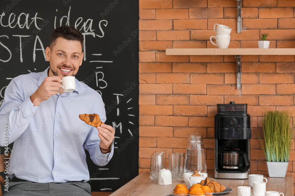 Businessman drinking coffee in kitchen of office