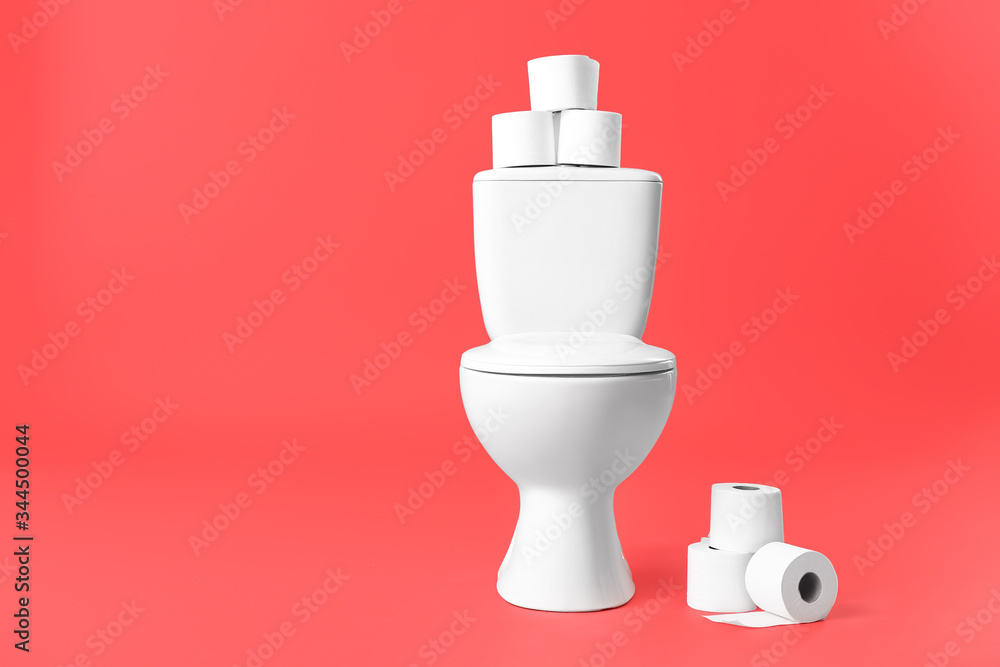 Toilet bowl with rolls of paper on color background