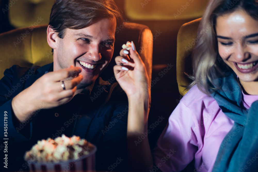 Caucasian lover enjoying to watch movie and eating popcorn together in the cinema