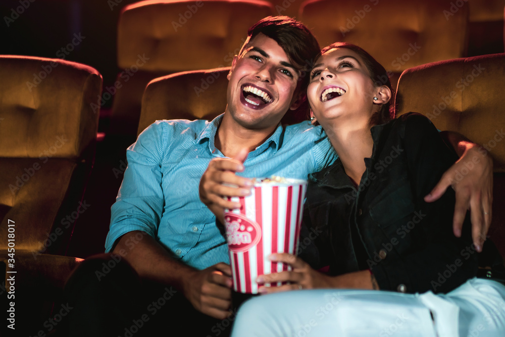 Man and woman watching movie in the movie theater cinema. Group recreation activity and entertainmen