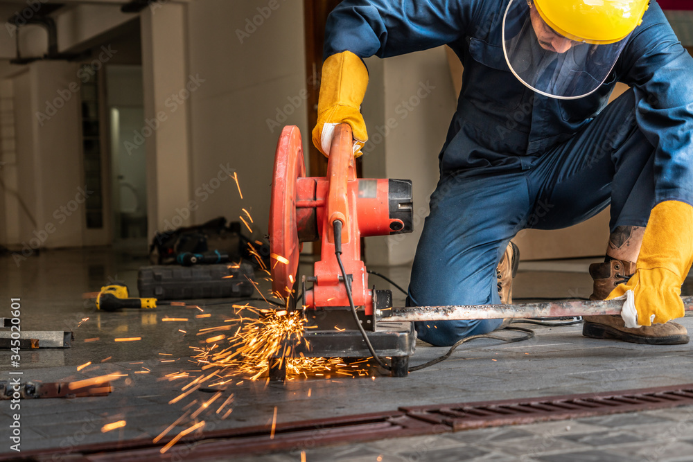 Professional mechanic is cutting steel metal with rotating diamond blade cutter. Steel industry and 