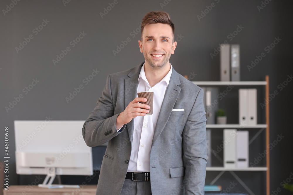 Young man drinking coffee in office