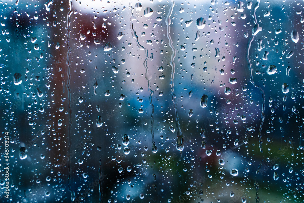 Raindrops on window glass. Selective focus. Rainy city background