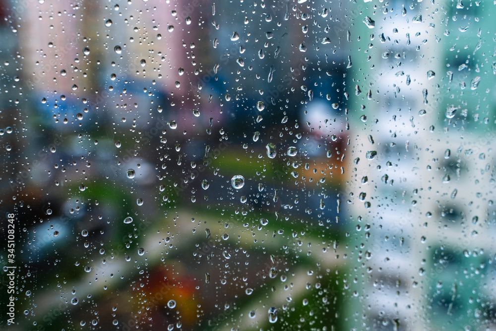 车窗玻璃上的雨滴。选择性聚焦。雨天城市背景