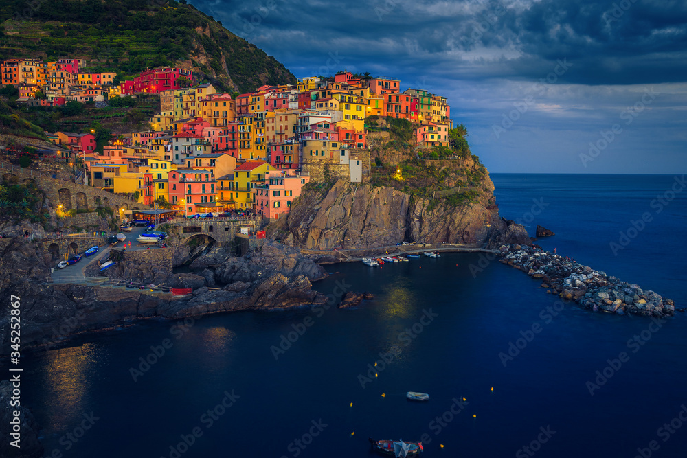 Colorful buildings on the cliffs at evening, Manarola village, Italy