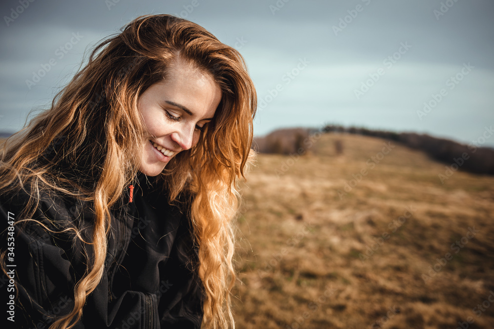 Happy young woman with long hair lifestyle portrait outdoor