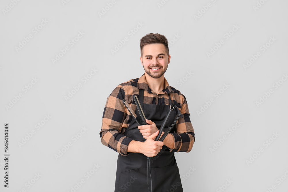 Male hairdresser on grey background