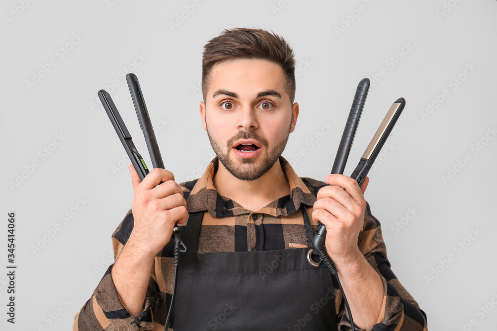 Male hairdresser on grey background