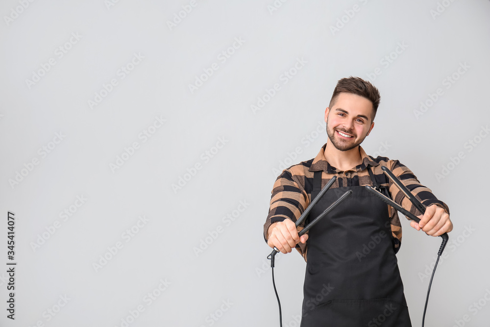 Male hairdresser on grey background