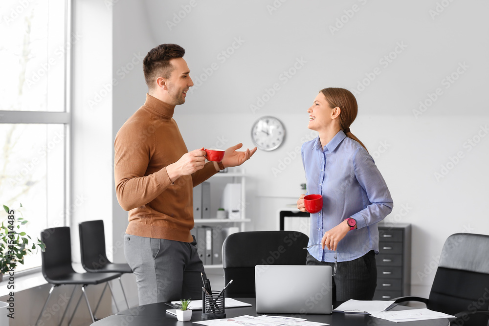 Young colleagues drinking coffee in office