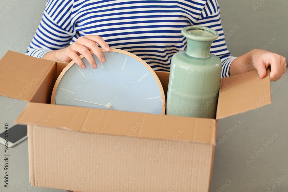 Young woman with moving box in her new home, closeup