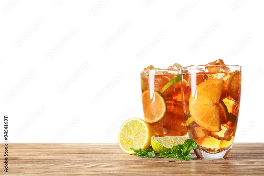 Glasses of tasty cold ice tea on table against white background