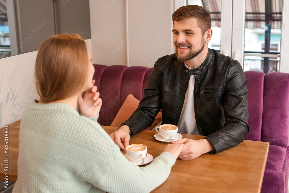 Young couple drinking coffee in cafe