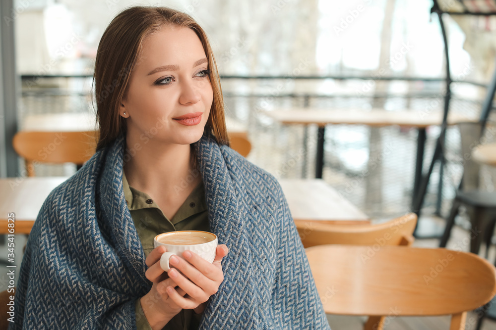 Young woman drinking coffee in cafe