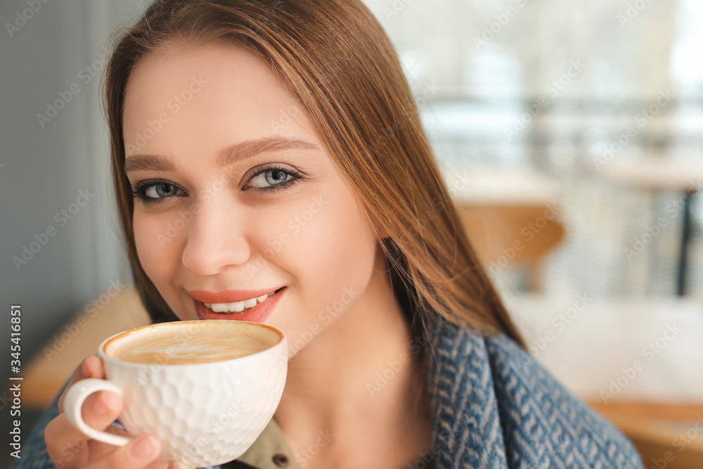 Young woman drinking coffee in cafe