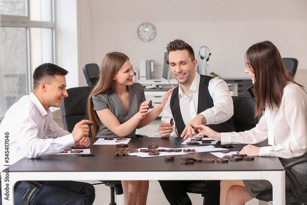 Team of business people composing words from letters in office