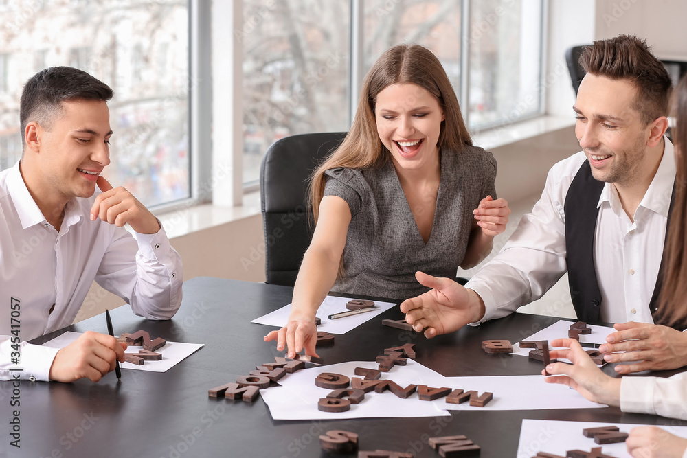 Team of business people composing words from letters in office