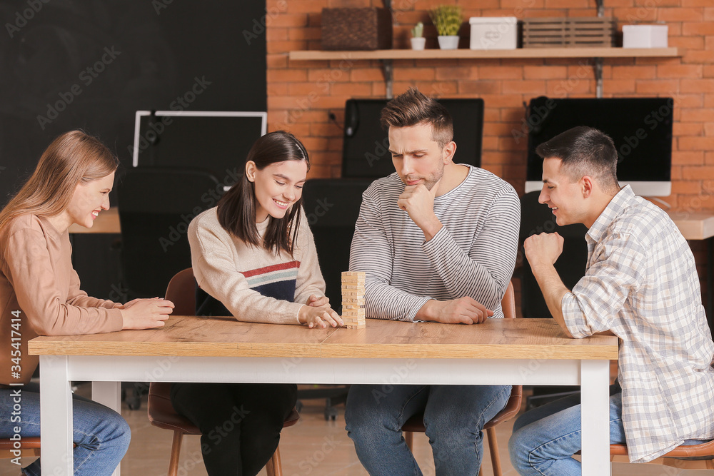 Team of business people playing jenga in office