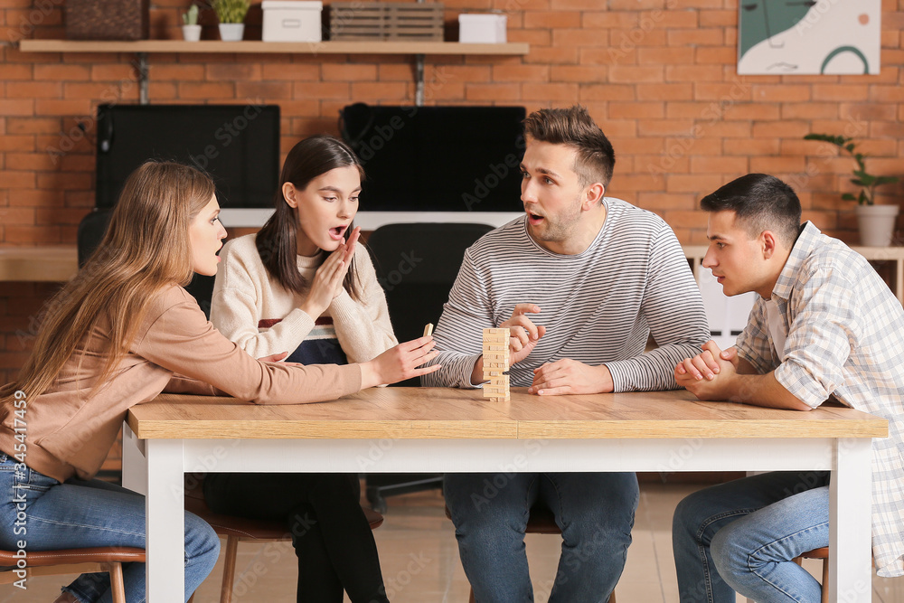 Team of business people playing jenga in office