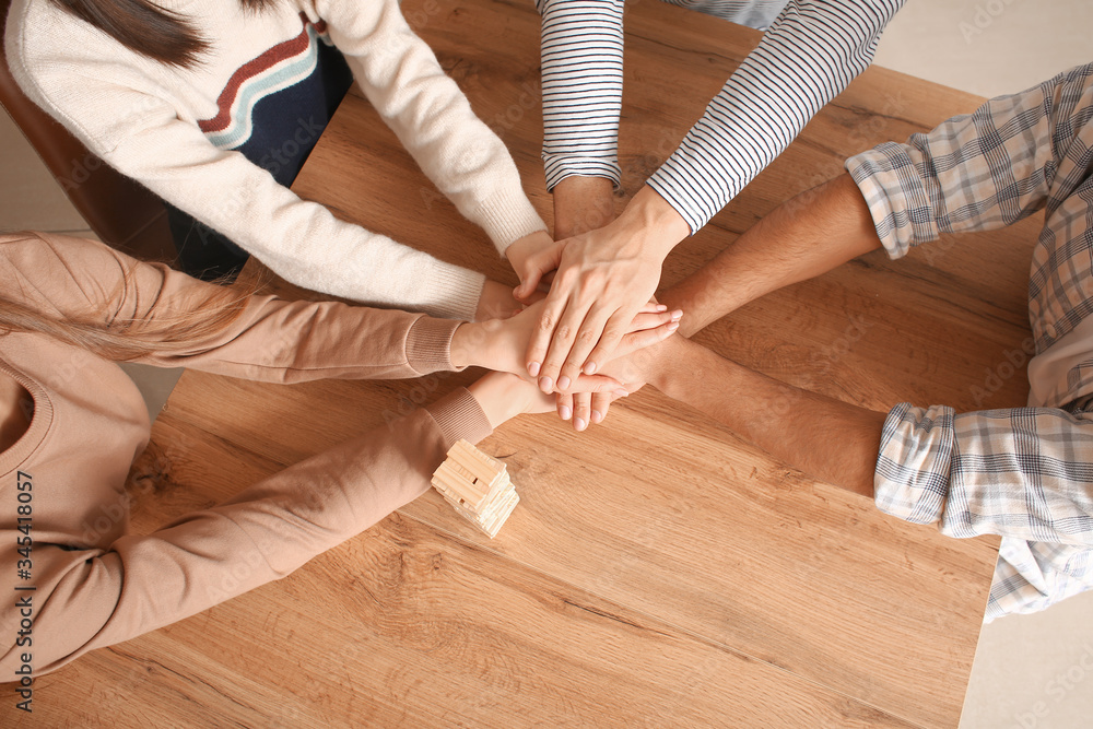 Team of business people putting hands together in office, top view