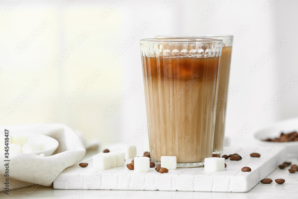 Glasses of tasty iced coffee with sugar on table