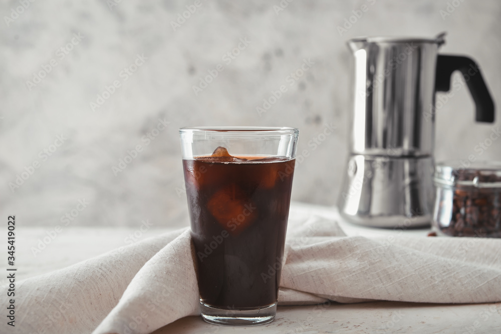 Glass of tasty iced coffee on table