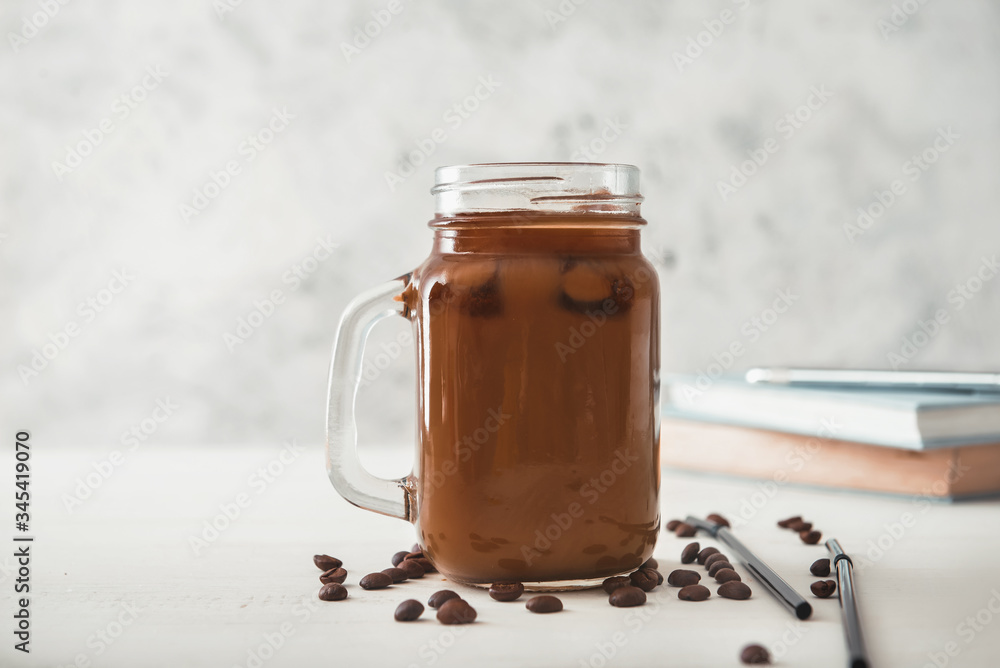 Mason jar of tasty iced coffee on table