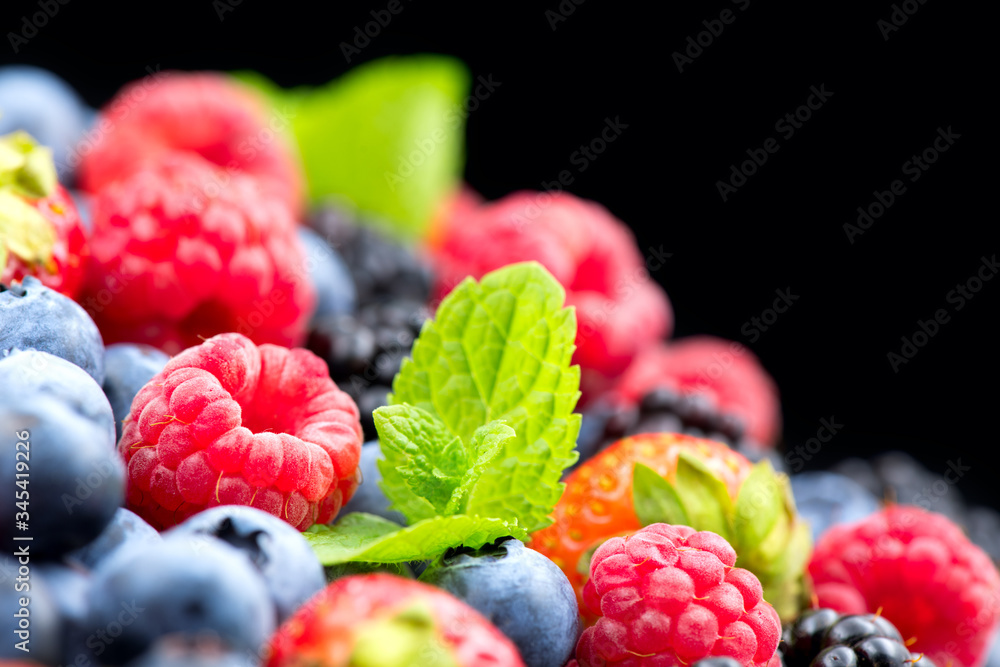 Berries. Various colorful berries background. Mint leaves, Strawberry, Raspberry, Blackberry, Bluebe