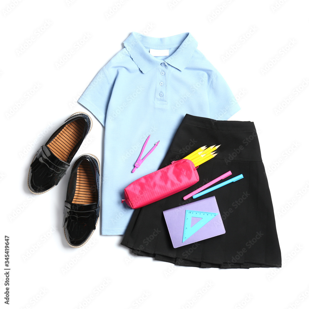 Stylish school uniform with stationery on white background