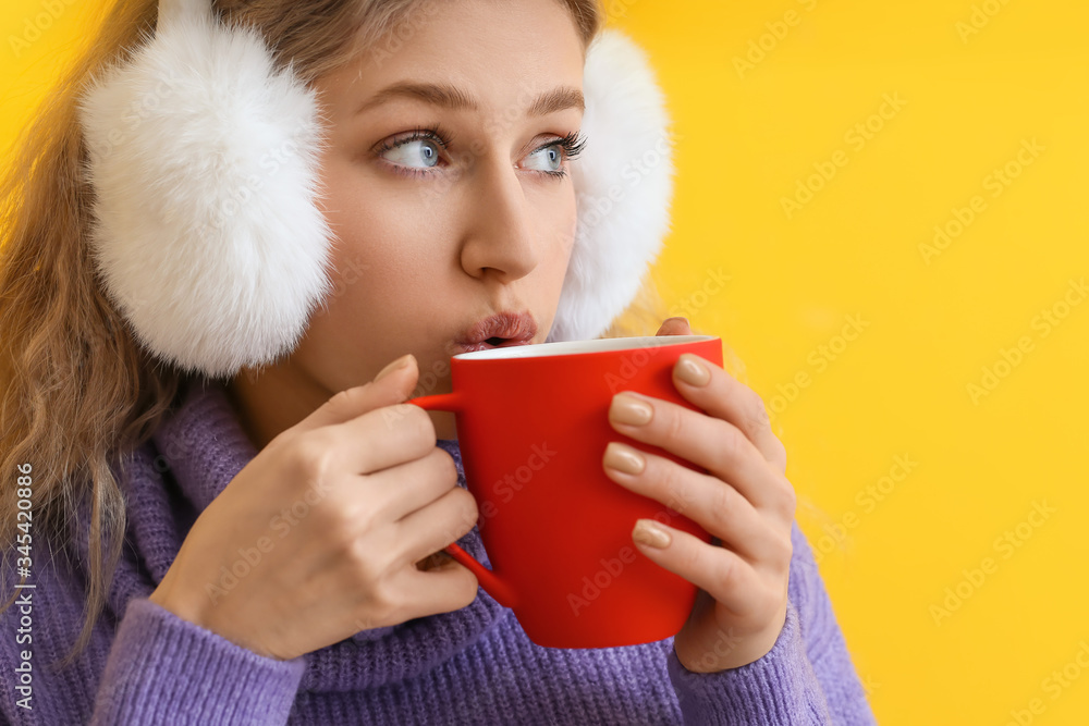 Beautiful young woman with cup of hot chocolate on color background