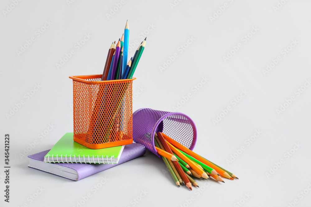 Holders with stationery on light background