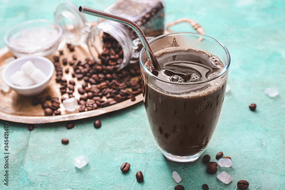 Glass of tasty iced coffee on color background