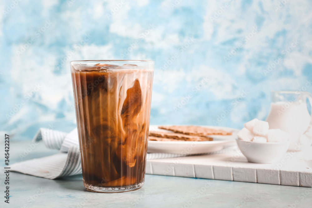 Glass of tasty cold coffee on color background