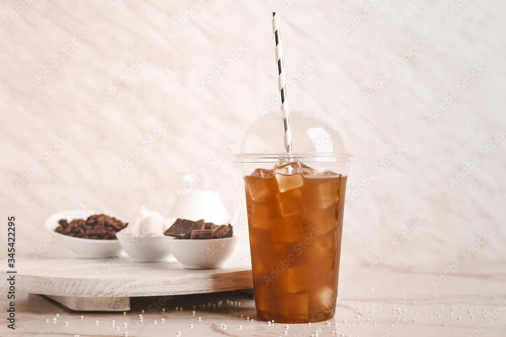 Cup of tasty cold coffee on light background