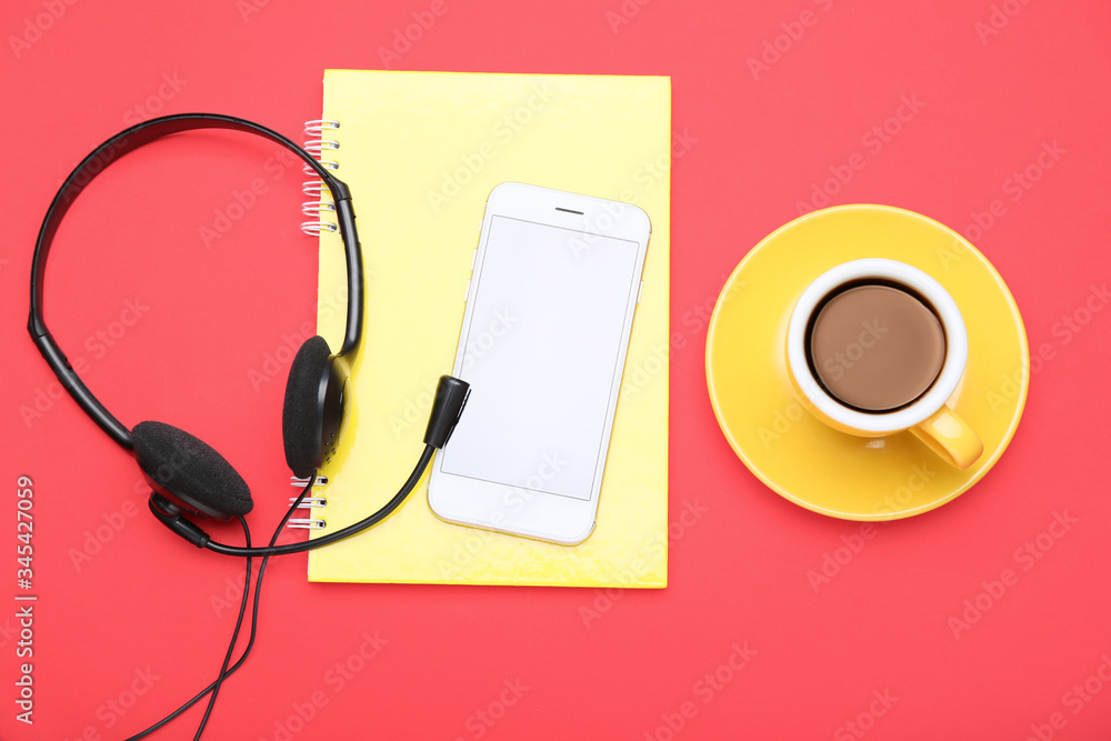 Notebook, mobile phone, headset and coffee on color background