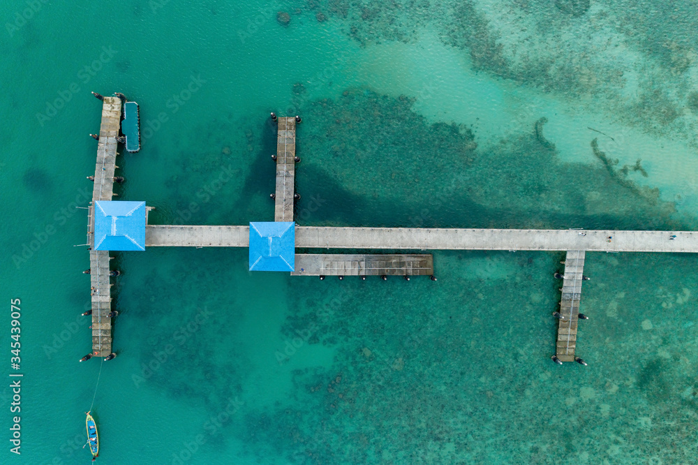 Aerial top view drone shot of long bridge in to the tropical sea.