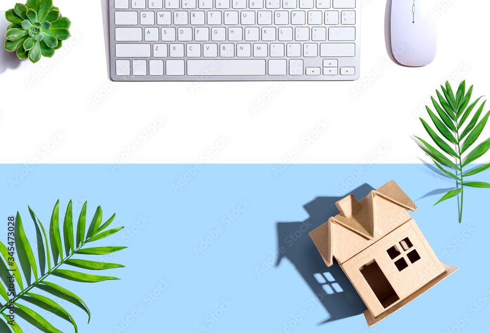 Cardboard house with computer keyboard - flat lay