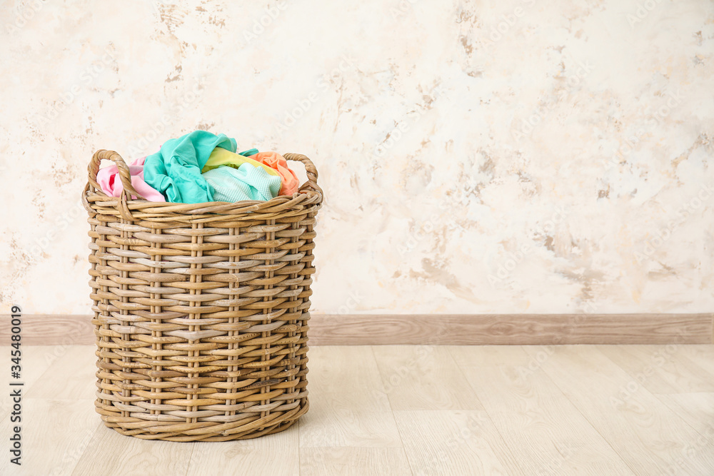 Wicker basket with laundry on floor