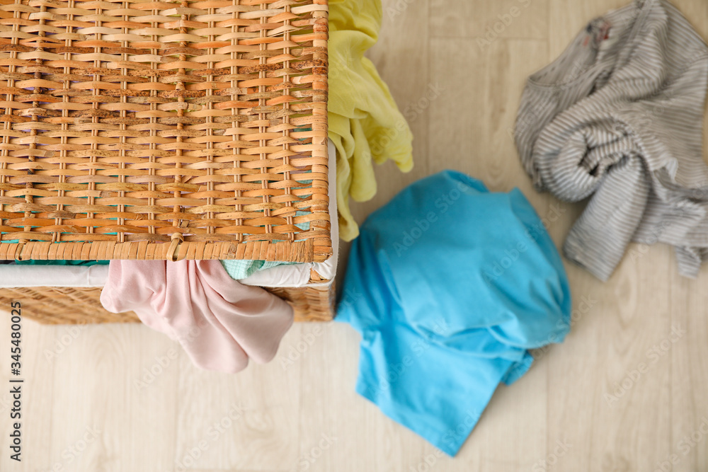 Wicker basket with laundry on floor