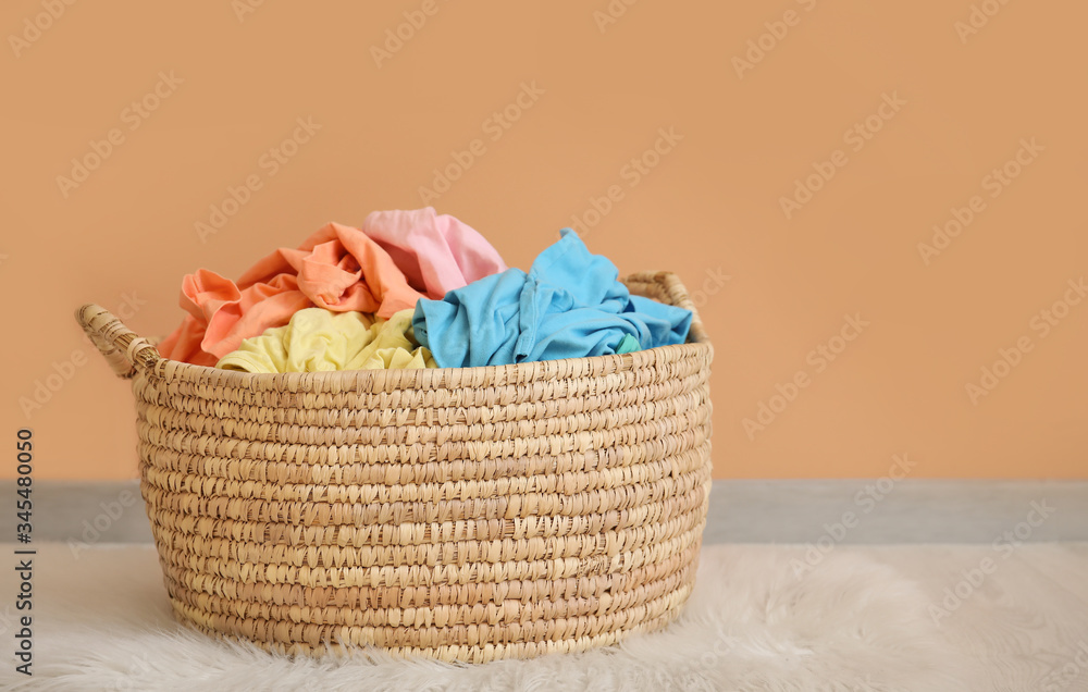 Wicker basket with laundry near color wall