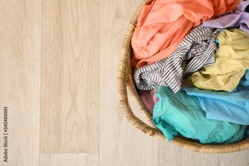 Wicker basket with laundry on floor